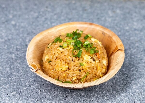 A bowl of egg fried rice topped with scallions